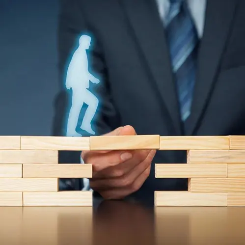 A man in a suit and tie holding onto some blocks